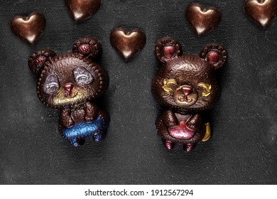 Two Hand Crafted Chocolate Bears And Many Hearts On A Dark Textured Background