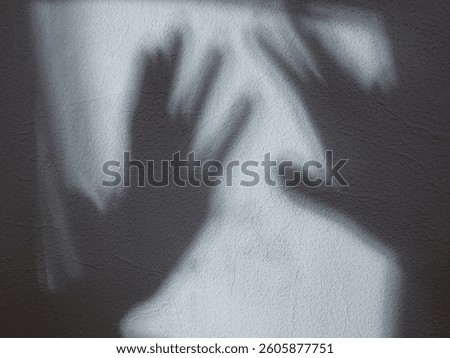 Two hand shadow silhouettes reaching on a light background