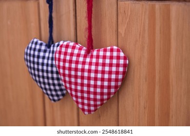 Two handcrafted hearts made of gingham fabric, one in red and the other in blue. - Powered by Shutterstock