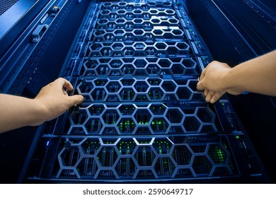 Two hands adjusting the metal components of a server rack in a modern data center. LED lights illuminate the intricate design and technology within.