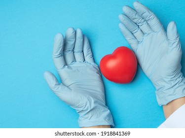 Two Hands In Blue Latex Gloves Holding A Red Heart, Donation Concept, Top View