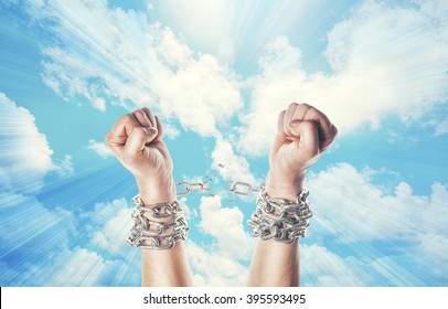 Two hands in chains on a heavens background with a flash