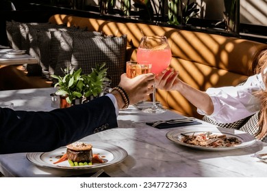 two hands cheering liquor glasses, whiskey and cocktail, fine dining restaurant