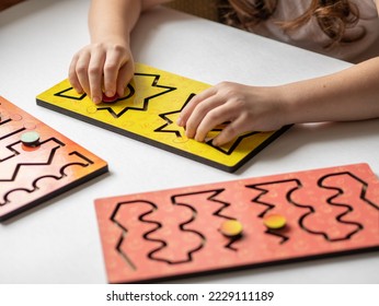 Two hands of a child with an interhemispheric board on a white table, correctional classes for children with speech disorders or neurology. - Shutterstock ID 2229111189