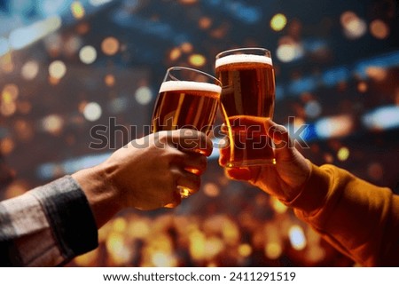 Two hands clinking with mug of cold foamy beer. People celebrating start of Oktoberfest. Selective focus. Blurred. Concept of cheers, toasts, party, celebration, taste, national traditions.