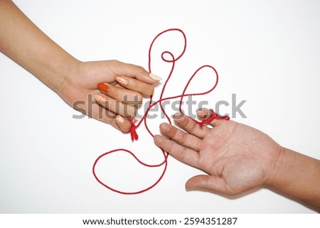 Two hands connected by a red string, symbolizing destiny and the invisible bond between people. Inspired by the East Asian "red thread of fate" legend, this minimalist composition represents love.