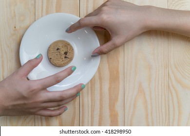 Two Hands Fight Over Last Cookie In White Plate.