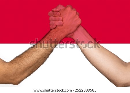 Two hands gathering front of Monaco flag, union of society, togetherness and solidarity concept, help or support for Monaco, human rights