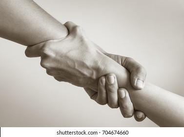 Two hands helping another. People helping each other.   - Shutterstock ID 704674660