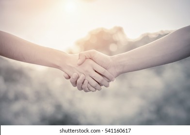 Two hands helping hand to a friend,Business man and woman shaking hands,helping hand concept and international day of peace