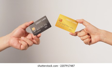 Two hands is hold black and gold credit card on white background.	 - Shutterstock ID 2207917487