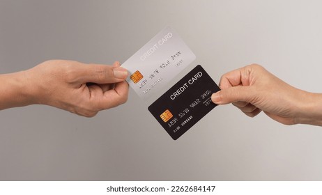 Two hands is hold black and silver credit card on white background.	 - Shutterstock ID 2262684147