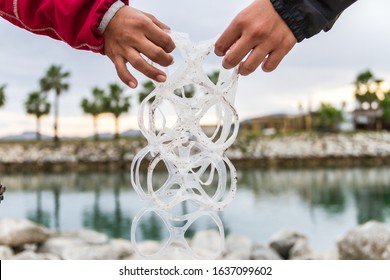 Two Hands Hold Six Pack Rings. Concept Photography About Environmental Care.