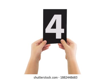 Two Hands Are Holding A Black Paper Card With Number 4 Isolated On White Background.