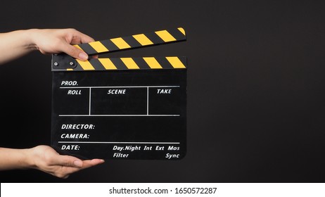 Two Hands Is Holding Clapper Board Or Movie Slate.It Is Used In Video Production And Film Industry On Black Background.