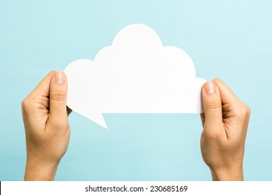 Two hands holding a cloud on blue background. Internet concept.