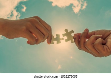 two hands holding  connect puzzle piece. Jigsaw against sun rays. symbol of association and connection concept. business strategy and success teamwork in business. - Shutterstock ID 1532278055