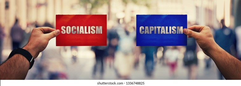 Two hands holding different colored paper sheet as socialist centralized economic planning versus capitalist liberated free market over crowded street background. Future strategy concept red vs blue.