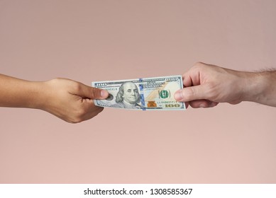 Two Hands Holding Dollar Bill. Hands Sharing US Money. Paying Or Trading Concept.