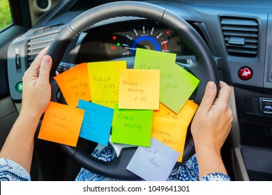 Two Hands Holding Driving Wheel And To Do List In A Car - Busy Day Concept