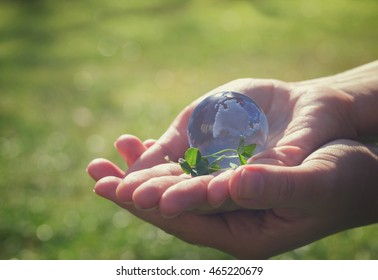 Two hands holding glass globe outdoor, concept for environment protection, retro toned - Shutterstock ID 465220679