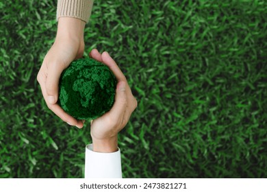 Two hands holding green earth together on nature background for the Sustainable Development Goals. Responsibility for the environment.Global community teamwork. Ecosystem. Save world. - Powered by Shutterstock