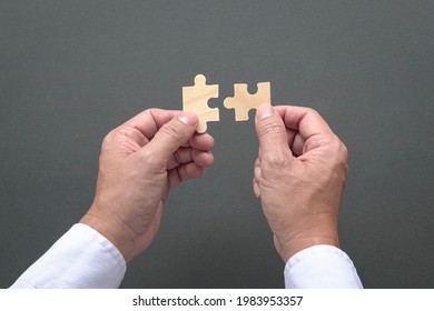 Two Hands Holding Jigzaw Puzzles, Business Matching, Finding The Right Fit Concept.