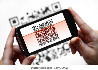 Two Hands Holding A Mobile Phone Scanning A QR Code