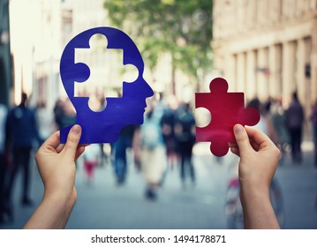Two hands holding a paper with human head and a puzzle piece. Finding a cure to heal the disease. Mental health concept, memory loss and dementia disease. Alzheimer's losing brain and memory function.
