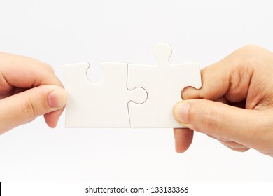 Two Hands Holding Puzzle Pieces And Connecting Them