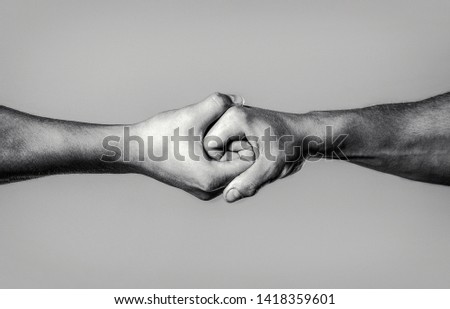 Two hands, isolated arm, helping hand of a friend. Rescue, helping hand. Male hand united in handshake. Man help hands, guardianship, protection. Black and white.
