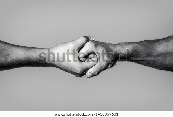 Two hands, isolated arm,\
helping hand of a friend. Rescue, helping hand. Male hand united in\
handshake. Man help hands, guardianship, protection. Black and\
white.
