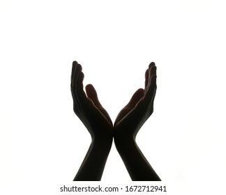 The Two Hands Are Joined, And The Palms Of The Hands Are Open, As If Holding Something. Dark Hands Silhouetted Against A White Background. The Palms Form The Letter V. Hands Hold The Ball.