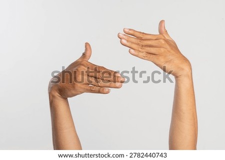 Two hands making a communication gesture isolated on gray background, symbolizing conversation, interaction, and expression.