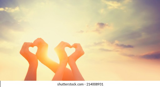 Two hands on sunset. - Shutterstock ID 214008931