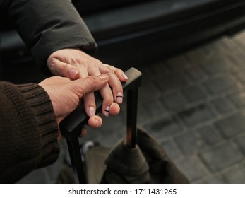 Two hands of people in love on the handle of a suitcase, traveling together. Day - Shutterstock ID 1711431265