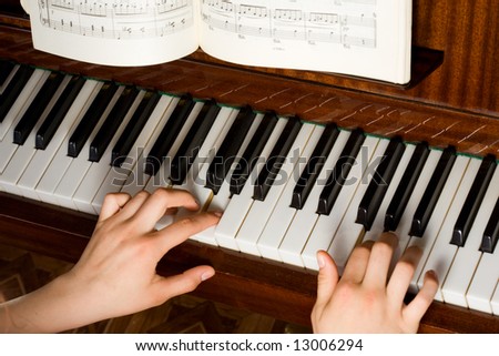 Two hands playing on the piano