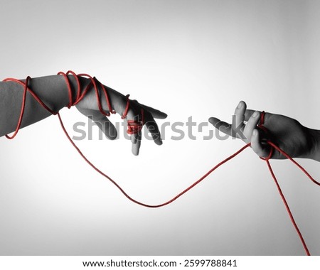 Two hands with a red string connecting them