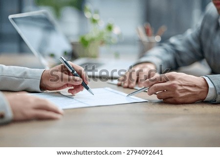 Two hands sign a document at a table. Laptop and pen rest nearby. Soft lighting suggests a professional meeting. Focus is on the act of agreement or commitment. Use for business, legal