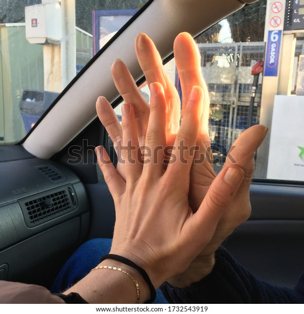two\
hands touching in a car. a big hand and a small\
hand.