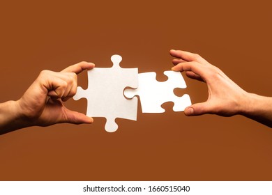 Two hands trying to connect couple puzzle. Businessman hand connecting jigsaw puzzle. Closeup hands of man connecting jigsaw puzzle. Business solutions, success and strategy concept. - Shutterstock ID 1660515040