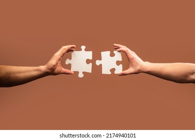 Two hands trying to connect couple puzzle piece on gray background. Teamwork concept. Closeup hand of connecting jigsaw puzzle. - Shutterstock ID 2174940101