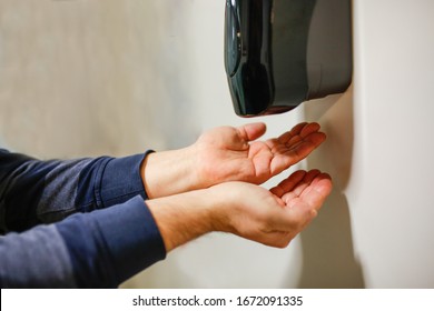 Two Hands Under The Automatic Alcohol Dispenser.