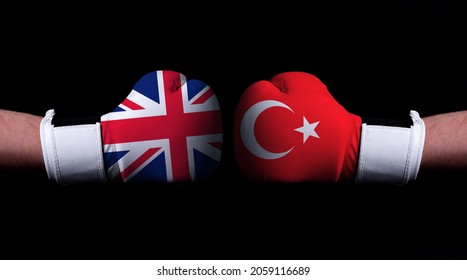 Two Hands Of Wearing Boxing Gloves With Turkey And United Kingdom Flag. Boxing Competition Concept. Confrontation Between Two Countries