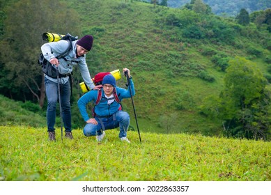 Two handsome Asian man friends backpacker with backpack hiking together on mountain trail. Healthy male friendship enjoy outdoor activity and active lifestyle climbing and camping in summer vacation.