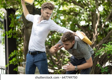 Two Handsome And Young Furious Men Fighting With Each Other In The Garden.