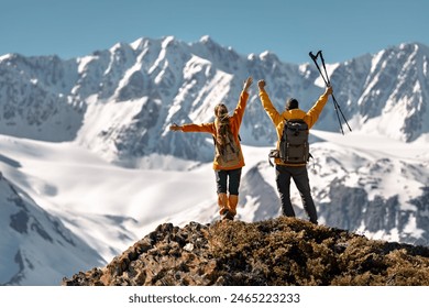 Two happy active hikers are standing in winner pose with open arms against glacier and mountain - Powered by Shutterstock