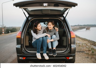 Two Happy Asia Woman Friends Enjoying Road Trip In Hatchback Car,flare Light