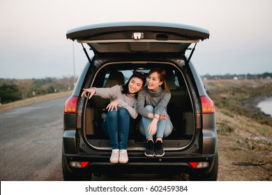 Two Happy Asia Woman Friends Enjoying Road Trip In Hatchback Car,flare Light