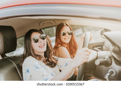 Two Happy Asian Girl Best Friends Laughing And Smiling In Car During A Road Trip To Vacation.